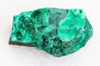 macro shooting of natural mineral rock specimen - rough green malachite stone on white marble background from Katanga Copper Crescent, Catanga in Congo