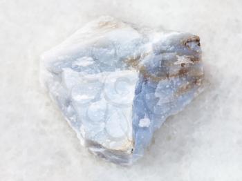 macro shooting of natural mineral rock specimen - raw Angelite (Blue Anhydrite) stone on white marble background from North Caucasian region, Russia