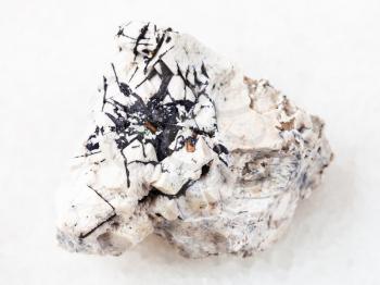 macro shooting of natural mineral rock specimen - Ilmenite black crystals on stone on white marble background from Khibiny Mountains, Kola Peninsula in Russia