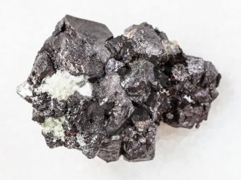 macro shooting of natural mineral rock specimen - raw crystalline Magnetite stone on white marble background