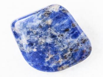 macro shooting of natural mineral rock specimen - polished Sodalite gemstone on white marble background from Bolivia