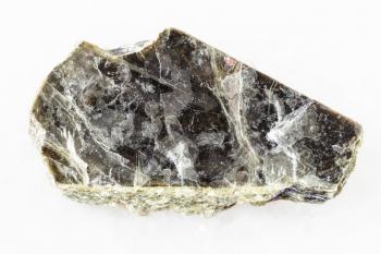 macro shooting of natural mineral rock specimen - rough muscovite mica stone on white marble background from Pirtima mine, Karelia, Russia