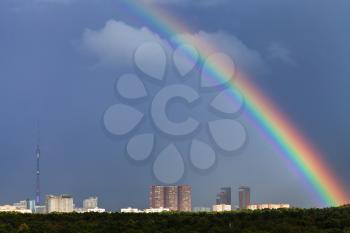 rainbow in dark blue sky over Moscow city with TV tower and Timiryazevskiy urban park