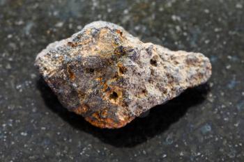 macro shooting of natural mineral rock specimen - raw Psilomelane (manganese ore) stone on dark granite background