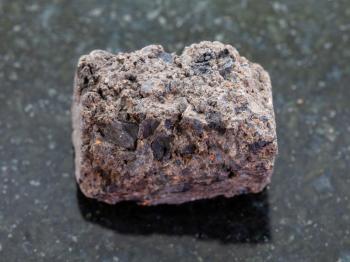 macro shooting of natural mineral rock specimen - raw Peat Turf stone on dark granite background