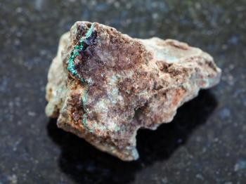 macro shooting of natural mineral rock specimen - Malachite (copper ore) stone on dark granite background