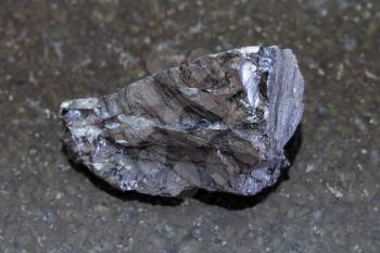 macro shooting of natural mineral rock specimen - rough Anthracite coal on dark granite background