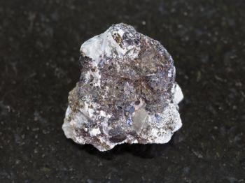 macro shooting of natural mineral rock specimen - rough sphalerite (zinc blende) stone on dark granite background
