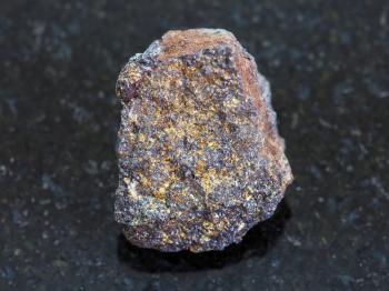 macro shooting of natural mineral rock specimen - rough magnetite (iron ore) stone on dark granite background