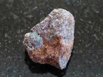 macro shooting of natural mineral rock specimen - raw magnetite (iron ore) stone on dark granite background