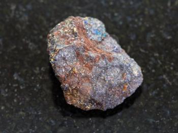 macro shooting of natural mineral rock specimen - magnetite (iron ore) stone on dark granite background
