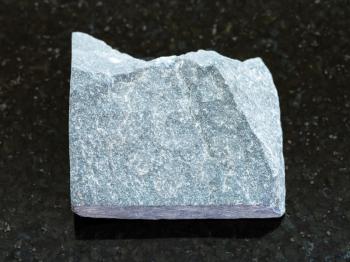 macro shooting of natural mineral rock specimen - rough Slate stone on dark granite background