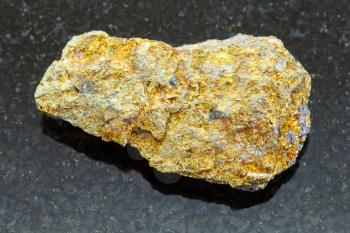macro shooting of natural mineral rock specimen - raw pyrite ore on dark granite background