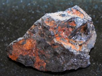 macro shooting of natural mineral rock specimen - rough Wolframite stone (tungsten ore) on dark granite background from Zabaykalsky Krai of Russia