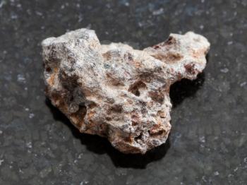 macro shooting of natural mineral rock specimen - raw Basalt stone on dark granite background