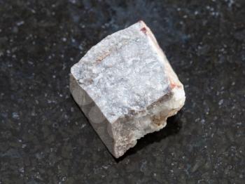 macro shooting of natural mineral rock specimen - raw Rhyolite stone on dark granite background