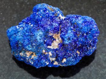 macro shooting of natural mineral rock specimen - rough crystalline Azurite stone on dark granite background from Rubtsovskiy mine, Altai Mountains, Russia