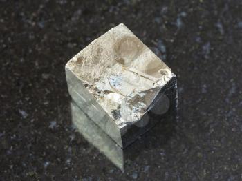 macro shooting of natural mineral rock specimen - rough pyrite crystal on dark granite background from Spain