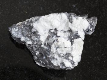 macro shooting of natural mineral rock specimen - Bismuthinite vein in raw quartz stone on dark granite background from Malkhanskoye mine (Malkhan) from Transbaikal region of Russia