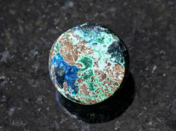 macro shooting of natural mineral rock specimen - sample of Chrysocolla gemstone on dark granite background