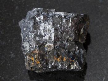 macro shooting of natural mineral rock specimen - raw Bituminous coal stone on dark granite background