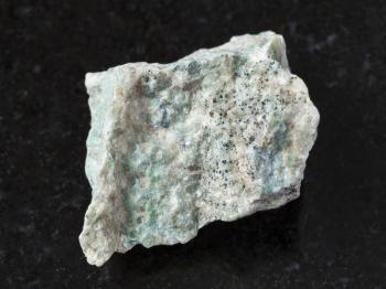 macro shooting of natural mineral rock specimen - raw Listwanite stone on dark granite background