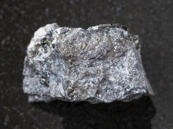 macro shooting of natural mineral rock specimen - Magnetite ore on dark granite background from Kovdor, Karelia, Russia