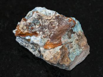 macro shooting of natural mineral rock specimen - raw Scorodite stone on dark granite background from Jezkazgan region, Kazakhstan