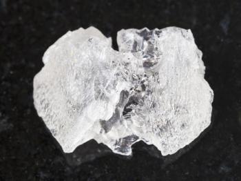 macro shooting of natural mineral rock specimen - raw crystal of Danburite gemstone on dark granite background from Dalnegorsk region, Primorsky Krai, Russia
