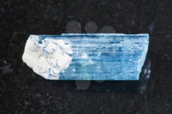 macro shooting of natural mineral rock specimen - raw crystal of aquamarine (blue beryl) gemstone on dark granite background from Sherlovaya Gora mine, Transbaikalia (Zabaykalye), Russia