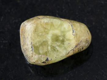 macro shooting of natural mineral rock specimen - green beryl gem stone on dark granite background
