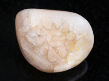 macro shooting of natural mineral rock specimen - polished Stilbite gemstone on dark granite background from India