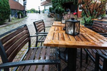 travel to Germany - empty wooden wet table in outdoor cafe in rain in Schnoor quarter of Bremen city