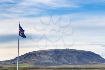 travel to Iceland - icelandic flag and view of mount near Kerid Lake in september evening