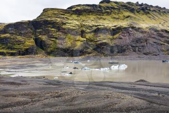 travel to Iceland - melting ice in water from Solheimajokull glacier (South glacial tongue of Myrdalsjokull ice cap) in Katla Geopark on Icelandic Atlantic South Coast in september