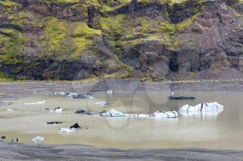 travel to Iceland - melting ice in puddle near Solheimajokull glacier (South glacial tongue of Myrdalsjokull ice cap) in Katla Geopark on Icelandic Atlantic South Coast in september