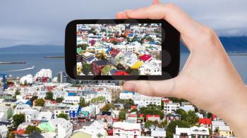 travel concept - tourist photographs Reykjavik city in Iceland in september on tablet