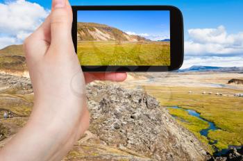 travel concept - tourist photographs Landmannalaugar area of Fjallabak Nature Reserve in Highlands region in Iceland in september on smartphone