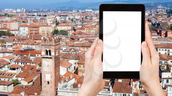 travel concept - tourist photographs above view of Verona city with Torre del Gardello from tower Torre dei Lamberti in spring on tablet with cut out screen for advertising logo