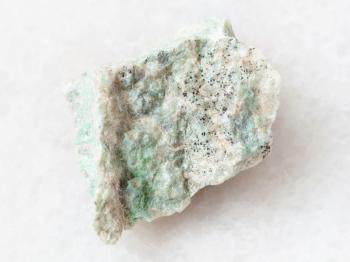macro shooting of natural mineral rock specimen - raw Listwanite stone on white marble background