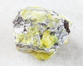 macro shooting of natural mineral rock specimen - rough sulfur ore on white marble background from Volodinskoye mine, Samara region, Russia
