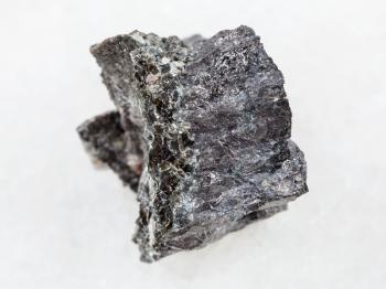 macro shooting of natural mineral rock specimen - raw Magnetite ore on white marble background from Kovdor, Karelia, Russia
