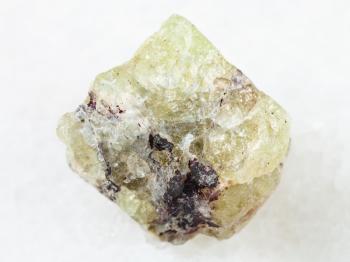macro shooting of natural mineral rock specimen - rough crystal of Saamite (fluorapatite) gemstone on white marble background from Lovozero Massif, Kola peninsula, Russia
