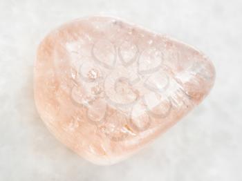 macro shooting of natural mineral rock specimen - morganite (pink beryl) gemstone on white marble background from Ural Mountains, Russia