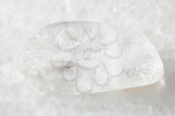 macro shooting of natural mineral rock specimen - polished Natrolite gemstone on white marble background from Lovozero Massif, Kola peninsula, Russia
