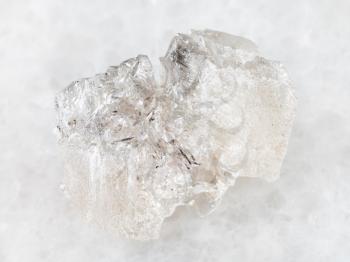 macro shooting of natural mineral rock specimen - rough crystal of Danburite gemstone on white marble background from Dalnegorsk region, Primorsky Krai, Russia