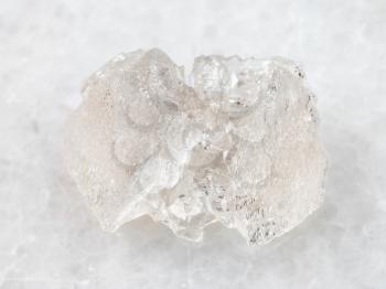 macro shooting of natural mineral rock specimen - raw crystal of Danburite gemstone on white marble background from Dalnegorsk region, Primorsky Krai, Russia