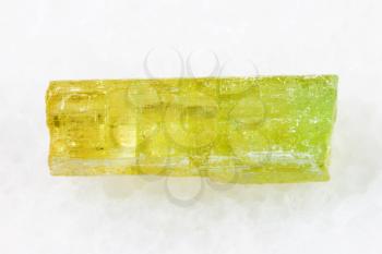 macro shooting of natural mineral rock specimen - raw crystal of Heliodor (yellow beryl) gemstone on white marble background from Sherlovaya Gora mine, Transbaikalia (Zabaykalye), Russia