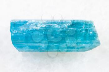 macro shooting of natural mineral rock specimen - crystal of aquamarine (blue beryl) gemstone on white marble background from Sherlova Gora (Sherlovaya Gora) mine, Transbaikalia (Zabaykalye), Russia