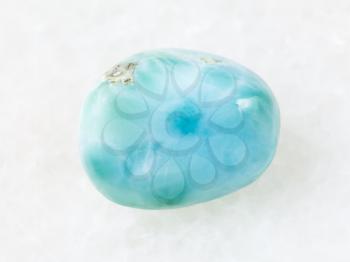 macro shooting of natural mineral rock specimen - polished Larimar gemstone on white marble background from Dominican Republic